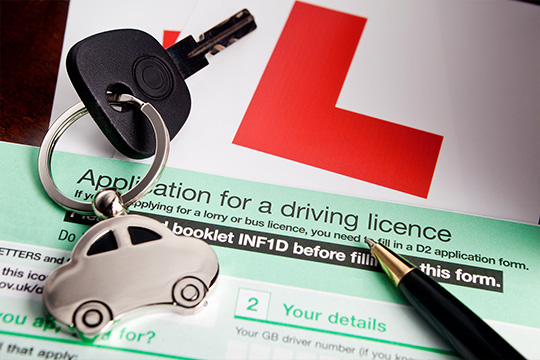driving licence application form with car keys and a pen