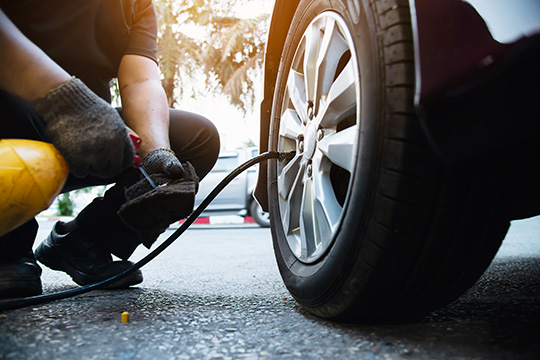 man putting air into car tyres