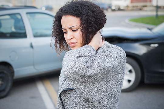 lady holding her neck after car accident