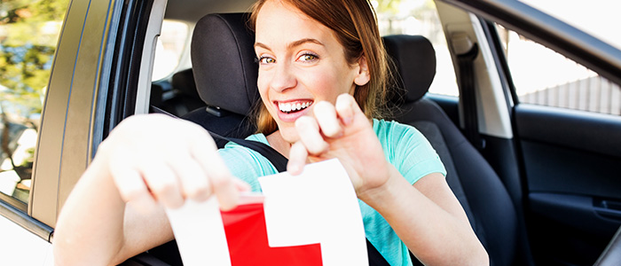 happy young lady driver ripping up L plates