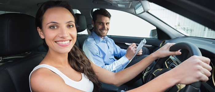 happy young lady driver with driving instructor