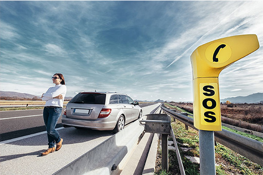 lady waiting at back of car for roadside assistance