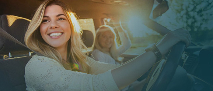 young lady driver smiling with mother in car