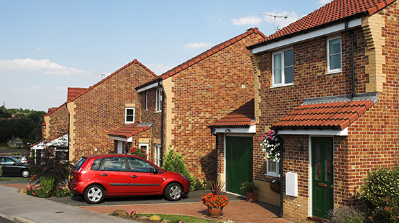 red family car parked on drive in housing estate