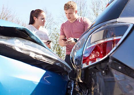 young drivers exchanging car details after road accident