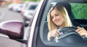 happy young lady driving alone in traffic