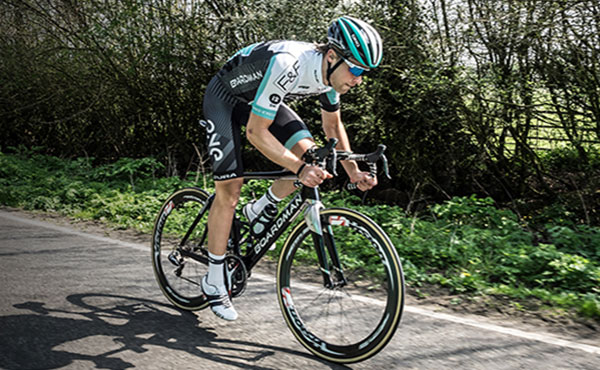 cyclist wearing cyclist gear riding his bike on country road