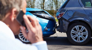 Older motorist calling emergency services after car accident