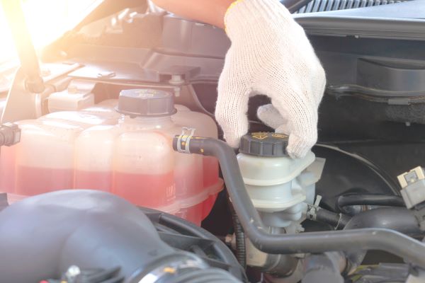 close up of a hand opening the brake fluid tank